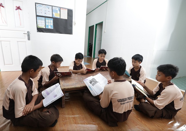 Rain (kanan) dan teman-temannya saat sedang belajar di ruang utama asrama mereka.