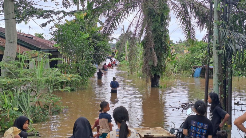 Warga di Kelurahan Meranti Pandak terpaksa menyelamatkan barang di rumah yang terendam banjir (foto/riki)