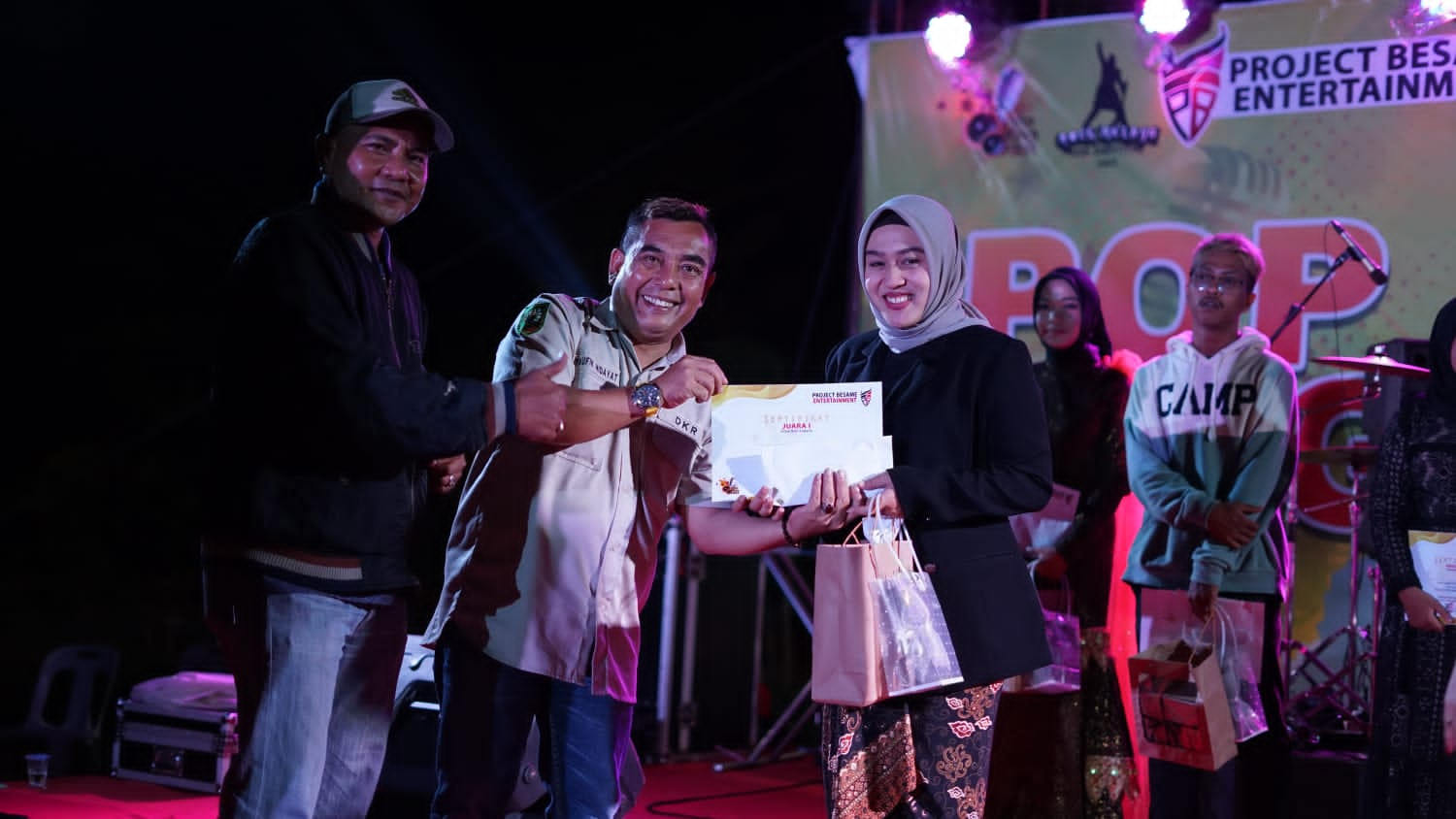 Ketua Dewan Kesenian Riau, Taufik Hidayat didampingi Ketua PWI Kepulauan Meranti, Syamsidir saat menyerahkan penghargaan kepada pemenang terbaik I Pop Singer Fest Meranti 2022