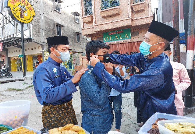 Walikota Dumai H Paisal membagikan masker kepada PKL di Jalan Sukajadi Dumai baru-baru ini.
