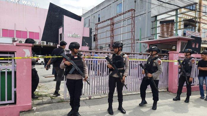 Personel Brimob Polda Riau berjaga di car wash yang jadi lokasi bentrokan diduga dua Ormas (foto/tribunpku)