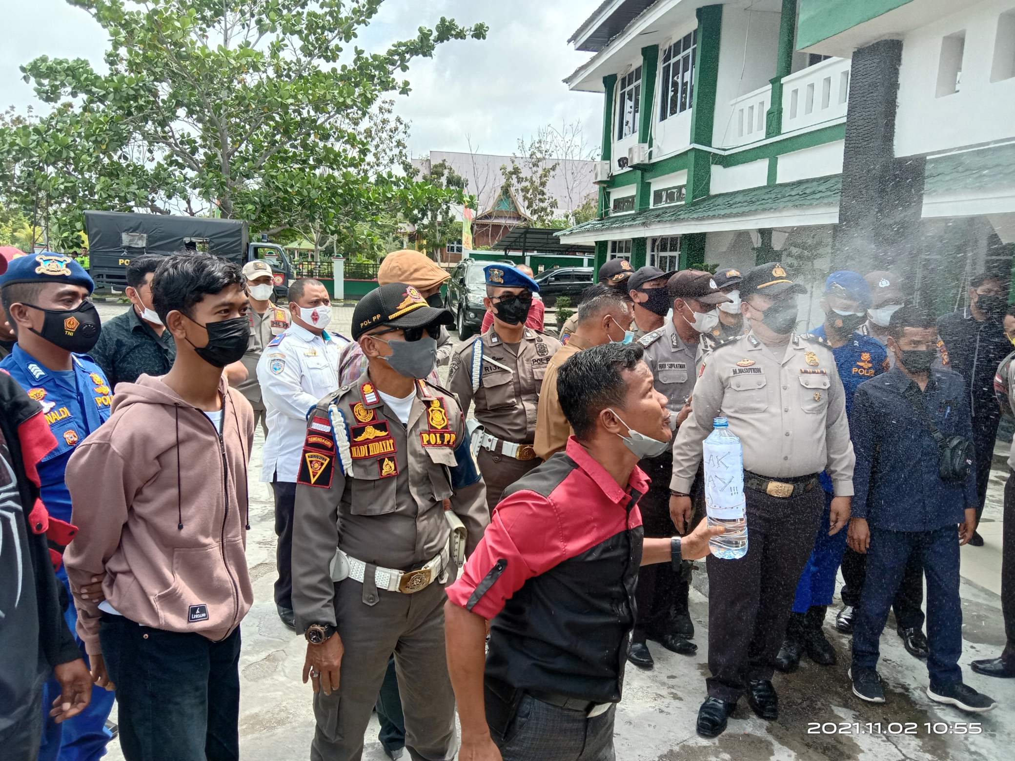 Ketua Umum LM2R, Jefrizal SH menyemburkan air tolak bala di halaman Kantor Bupati Kepulauan Meranti