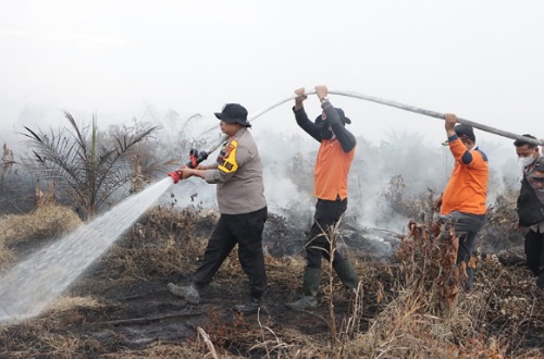 Kapolres Siak ikut lakukan pendinginan di lokasi Karhutla di Kampung Buantan Besar Siak.(foto: diana/halloriau.com)