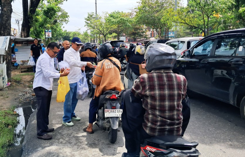 Ketua PWI Riau, Raja Isyam Azwar bersama pengurus berbagi sedekah ke pengendara (foto/ist)