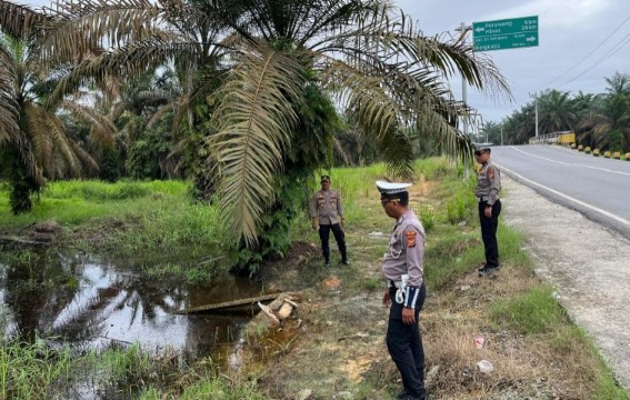 Kapolsek Tualang, Kompol Hendrix, bersama anggota memantau debit air di Jalan Lintas Pekanbaru-Siak (foto/diana)