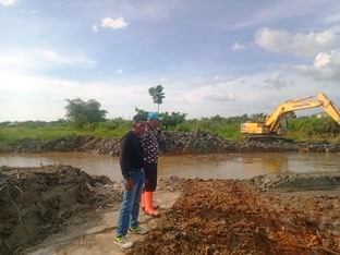 Pengerjaan normalisasi Danau Buatan oleh DLHK Rohil menggunakan alat berat.