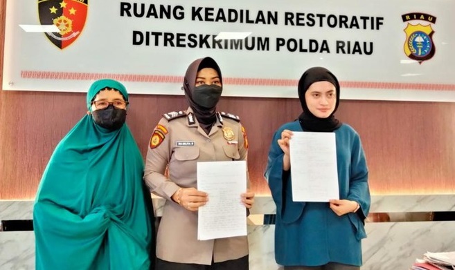 Riri (paling kanan) saat mencabut laporan dari Polda Riau.