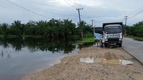 Kondisi Jalintim KM 83 Desa Kemang, Kecamatan Pangkalan Kuras, Kabupaten Pelalawan, Riau. Air telah merendam sisi kiri dan kanan badan jalan. (Foto: Tribun Pekanbaru)