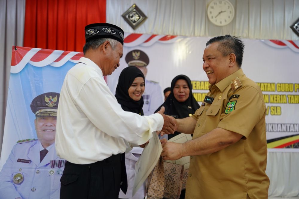 Pj Gubri, SF Hariyanto menyerahkan SK PPPK guru honor Kuansing dan Inhu (foto/int)