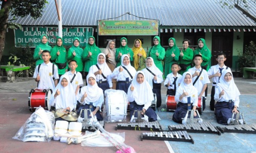 Ketua Persit Kartika Candra Kirana Koorcab Rem 031 PD I/BB, Ny Dr Widya Dany Rakca MMRS saat penyerahan alat marching band di SMP 1-5 Kartika.(foto: diana/halloriau.com)