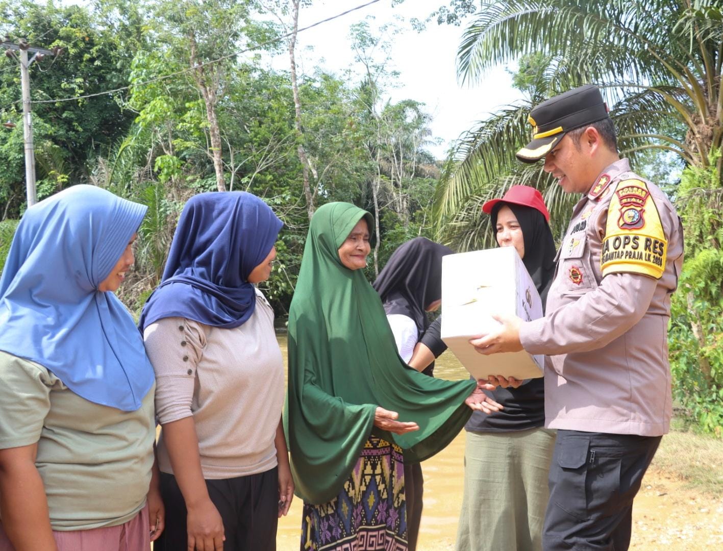 Kapolres Pelalawan, AKBP Afrizal serahkan bantuan sembako ke warga masyarakat terdampak kenaikan air Sungai Nilo Ukui (foto/Andy)