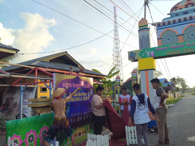 Kelompok seni Suryo Wijoyo Pesisir membuat gerbang lampu hias.