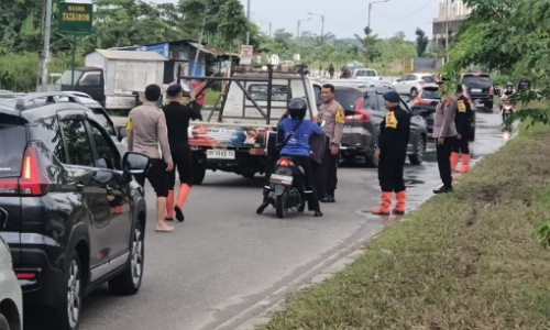 Kapolsek Rumpes, Kompol Tri Budiyanto turrun ke lokasi banjir bantu pengendara yang terjebak.(foto: istimewa)