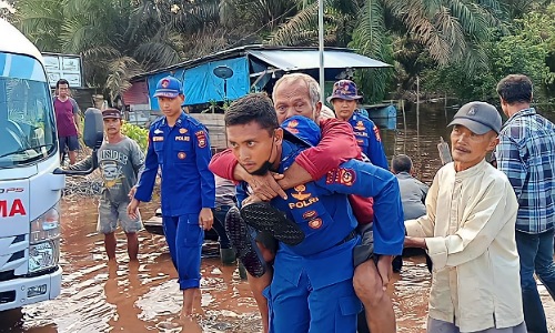 Kasat Polariud Polres Siak, AKP Togar Silalahi saat mengevakuasi lansia terdampak banjir.(foto: istimewa)