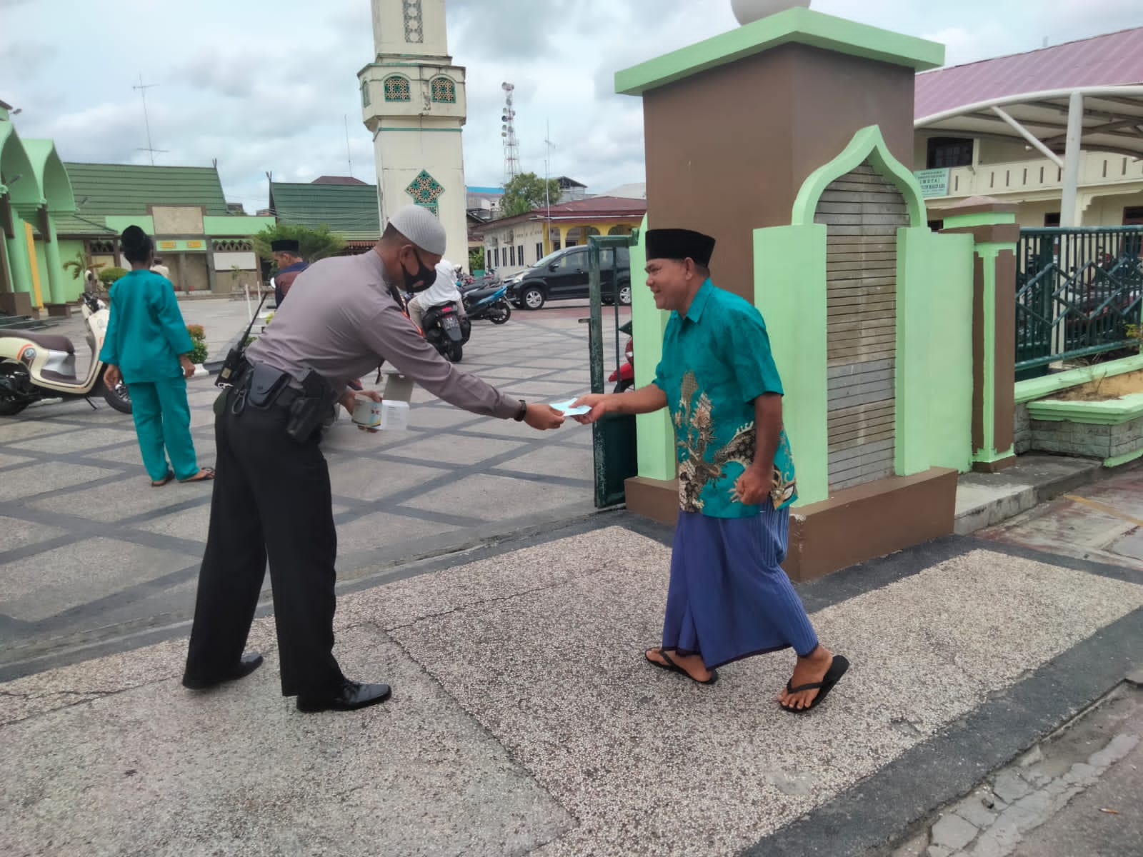 Terlihat Kabag Ops Polres Meranti, AKP Yudi Setiawan memberikan masker kepada jama