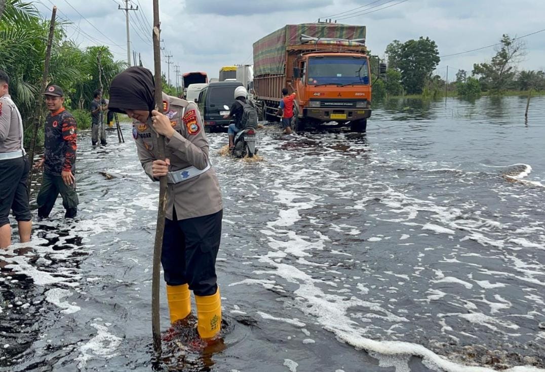 Polres Pelalawan pasang pembatas jalan di lokasi banjir Jalintim Desa Kemang (foto/Andy)