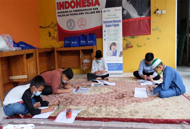 Anak-anak sedang belajar bersama dengan memanfaatkan koneksi internet fiber XL HOME Edutainment Zone di balai warga RW.16, Pondok Petir, Depok, Sabtu (19/12/2020). 