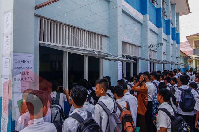 Calon siswa mengantre untuk melakukan pendaftaran saat Penerimaan Siswa Baru di SMKN 2 Pekanbaru, Riau, Selasa (3/7/2018). FOTO: Wahyudi