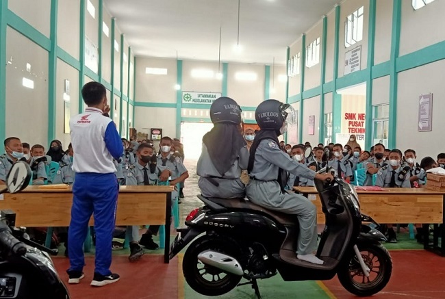 Instruktur Safety Riding saat menjelaskan tips berbeoncengan dengan posisi menyamping kepada seluruh siswa siswi SMKN 3 Mandau