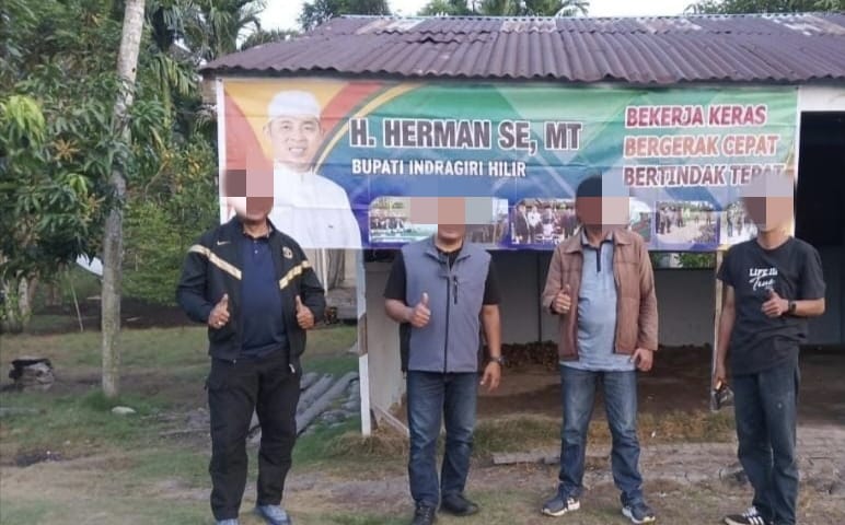 Fasilitator dan Pendamping Desa DMIJ-PT berfoto di spanduk bakal calon bupati, Herman di Kecamatan Belengkong (foto/ist)