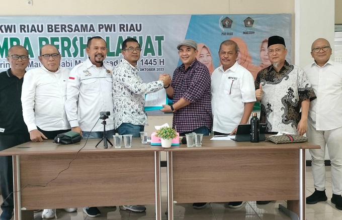 Ketua Bidang Organisasi PWI Pusat, Zulmansyah Sekedang menyerahkan hasil rapat pleno kepada Raja Isyam Azwar, Plt Ketua PWI Riau, Rabu (1/11/2023). Foto budy