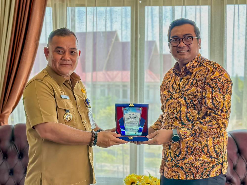 Pjs Wako Dumai Teuku Raja Fahsul Falah menerima cinderamata dari Area Head Bank Mandiri Dumau, Rizma Prabandhono (foto/bambang)