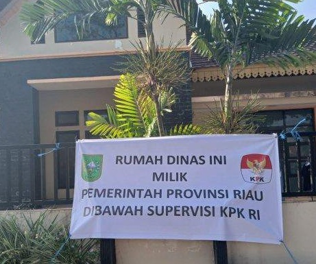 Spanduk bewarna putih itu bertuliskan "Rumah dinas ini milik Pemerintah Provinsi Riau Dibawah Supervisi KPK,".