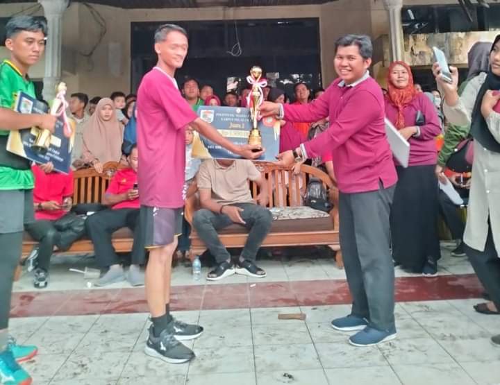 Koordinator PNP Kampus Pelalawan, Yumesri menyerahkan hadiah bagi pemenang open tournament volly ball (foto/Andi)