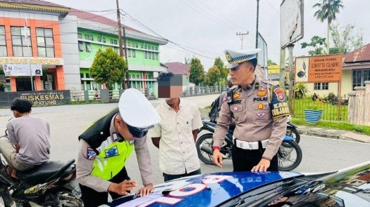 Petugas Sat Lantas Polres Inhu memberikan sanksi tilang kepada warga yang melanggar (foto/int)