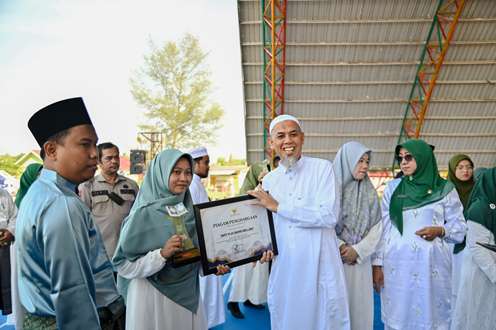 Walikota Dumai, H Paisal menyerahkan piagam penghargaan kepaa pelajar wisudawati tahfidz Quran di Dumai.(foto: bambang/halloriau.com)