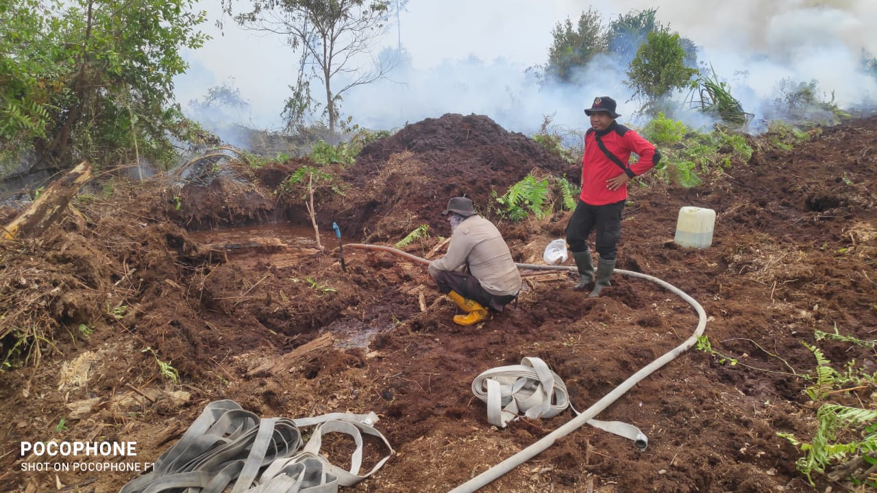 Petugas terlihat menyedot air dari dalam embung untuk sumber pemadaman Karhutla di Desa Mekar Delima, Tasik Putripuyu