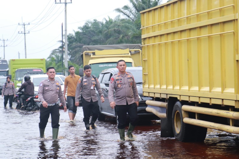 Kapolres Pelalawan, AKBP Afrizal kerahkan puluhan personel ke lokasi banjir di Km 83 (foto/Andy)