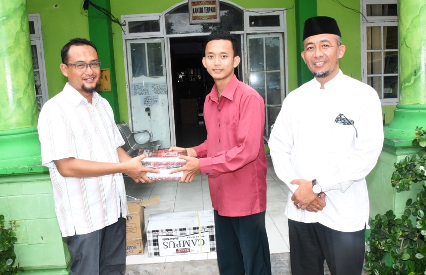 Kabid SDKI Adisutrisno menyerahkan buku tulis kepada ketua panitia MTQ.