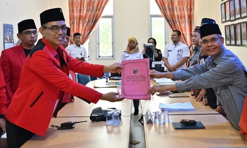 Ketua DPC PDIP Kota Dumai Uber Firdaus menyerahkan berkas pendaftaran Bacaleg kepada Ketua KPU Dumai, Darwis di kantor KPU Dumai Kamis (11/5/2023).(foto: bambang/halloriau.com)