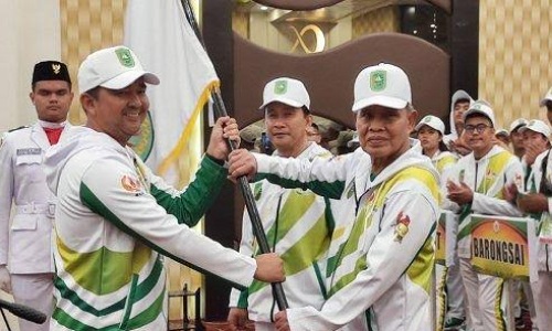 Kadispora Riau, Boby Rachmat menyerahkan bendera pataka kepada Ketua KONI Riau, Iskandar Hoesin dalam pengukuhan kontingan Riau untuk Porwil XI Sumatera.(foto: tribunpekanbaru.com)