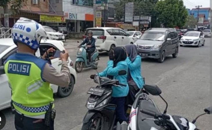 Ilustrasi Polantas Pekanbaru menilang pengendara yang tak pakai helm (foto/int)