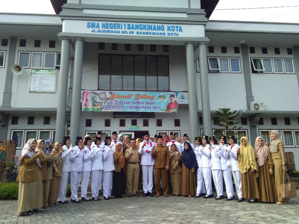 Aditya foto bersama dengan kepala sekolah dan para guru.