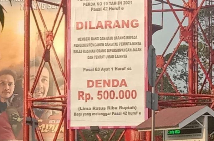 Spanduk sanksi denda bagi pengendara yang memberi uang pada gepeng.(foto: int)