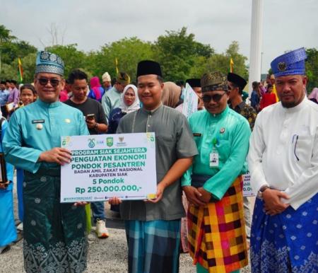 Baznas Kabupaten Siak menyerahkan bantuan kepada 717 mustahik, Pjs Bupati Siak Indra Purnama serahkan bantuan secara simbolis di halaman Kantor Bupati Siak, Sabtu (12/10/2024). 