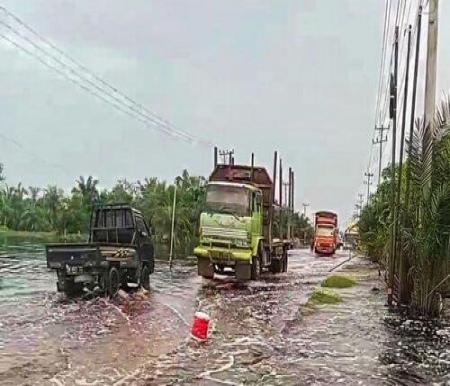 Debit air terpantau 20 Centimeter di lokasi banjir yang melanda Jalintim KM 83 Desa Kemang, Kecamatan Pangkalan Kuras, Kabupaten Pelalawan. (Foto: Tribun Pekanbaru)