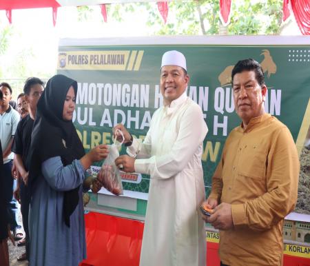 Kapolres Pelalawan, AKBP Suwinto bagikan daging kurban ke masyarakat (foto/andi)