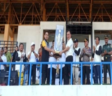 Kadispora Riau, Erisman Yahya menyerahkan Piala kepada Kontingen Pekanbaru sebagai juara umum Popda XVI Riau 2024.(foto: mcr)