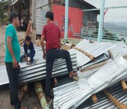 Warga Desa Tanjung Alai, Kecamatan XIII Koto Kampar membersihkan puing-puing warung yang rusak akibat puting beliung.(foto: mcr)