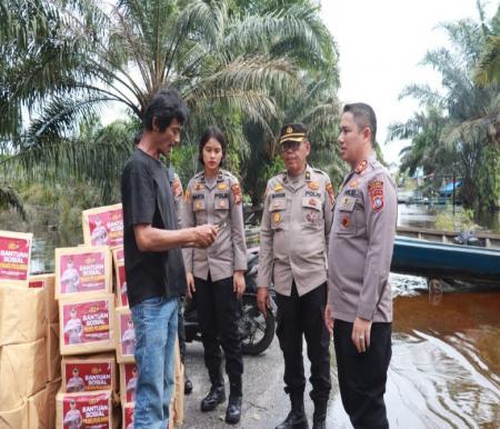 Kapolres Pelalawan, AKBP Afrizal salurkan bantuan sembako ke warga terdampak banjir Dusun Kualo (foto/Andy)