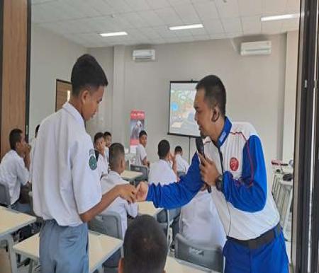 Instruktur Safety Riding CDN Riau, Arif Rahman Hakim memberikan materi safety riding kepada seorang siswa SMKN 5 Pekanbaru.(foto: istimewa)