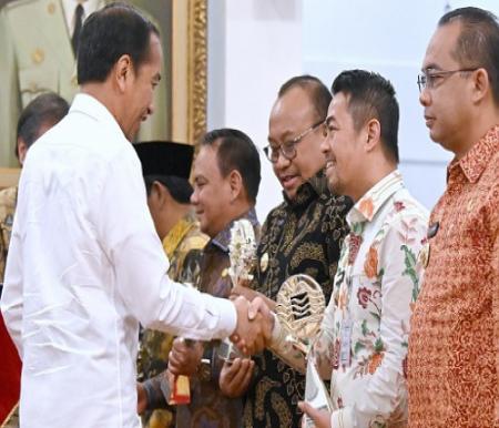 Presiden Jokowi menyerahkan penghargaan TPID kepada Pj Walikota Pekanbaru.(foto: pgi)
