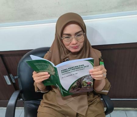 Seorang ASN membaca buku K3 yang ditulis Dr, Julnaidi, rencananya buku ini akan diluncurkan dan di Bedah di Hotel Pangeran Pekanbaru, Kamis 16 Januari 2025 mendatang