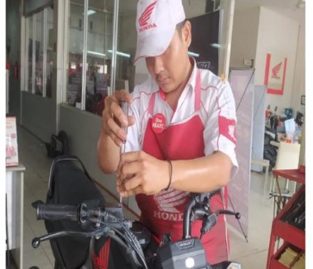 Mekanik Honda sedang melakukan pengecekkan minyak rem di salah satu motor konsumen setia Honda yang sedang service di AHASS.(foto: istimewa)