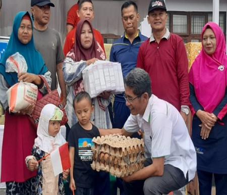 Manager PT TYE-PKR, Mario Anggriawan Tjuatja saat menyalurkan bantuan untuk anak-anak di Desa Kuapan.(foto: istimewa)