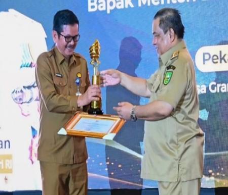 Pj Gubernur Riau, SF Hariyanto menyerahkan penghargaan kepada Sekdako Dumai, H Indra Gunawan.(foto: bambang/halloriau.com)
